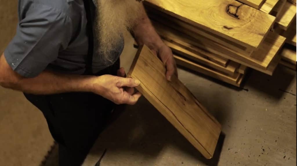 Amish employee inspecting wood